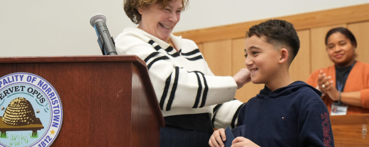 Grayson, a 2025 Steward for Tomorrow Youth Awardee, receives recognition at a Norristown town meeting in March 2026.